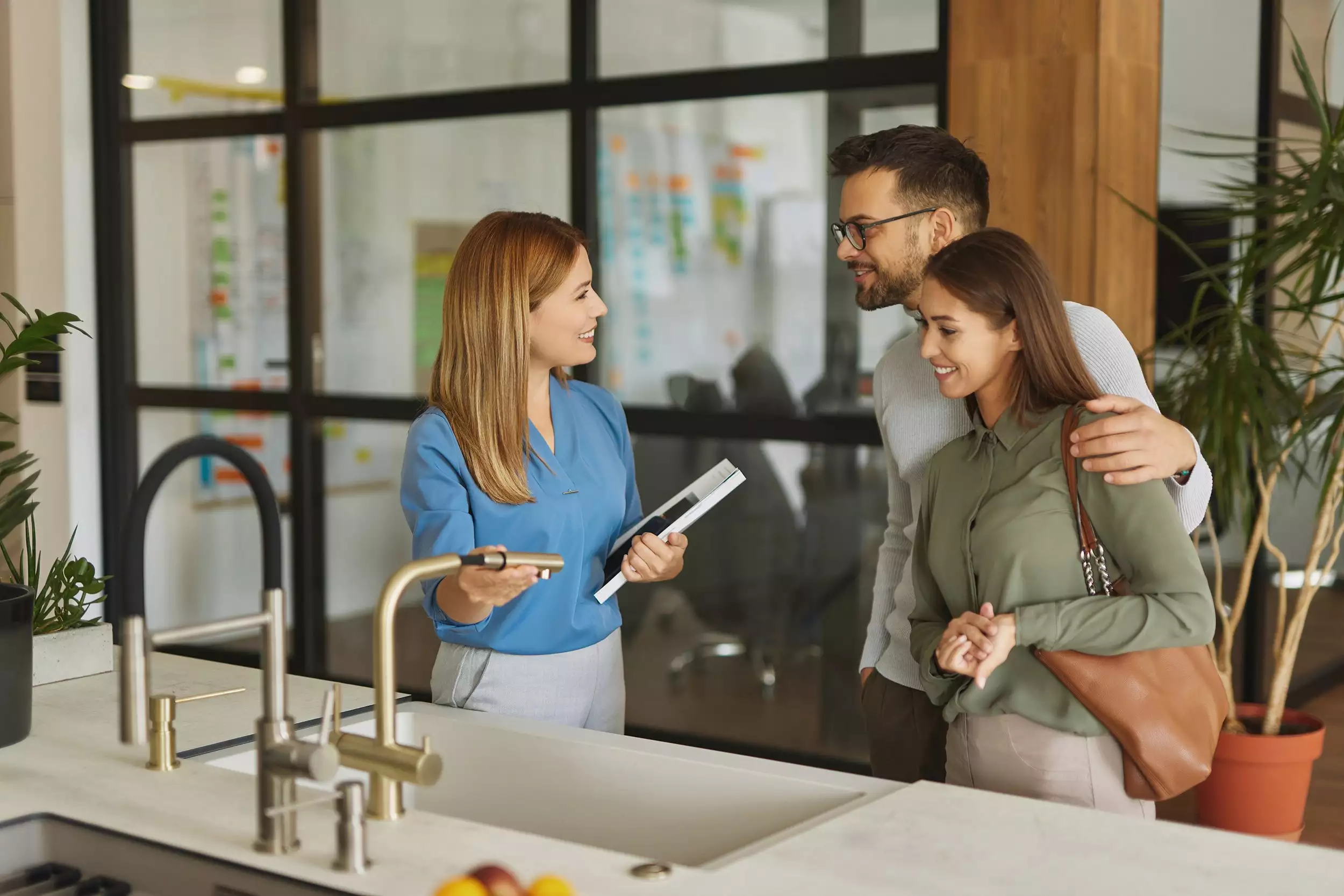 Specialist Showing a Couple Faucet/Sink in a Kitchen Showroom